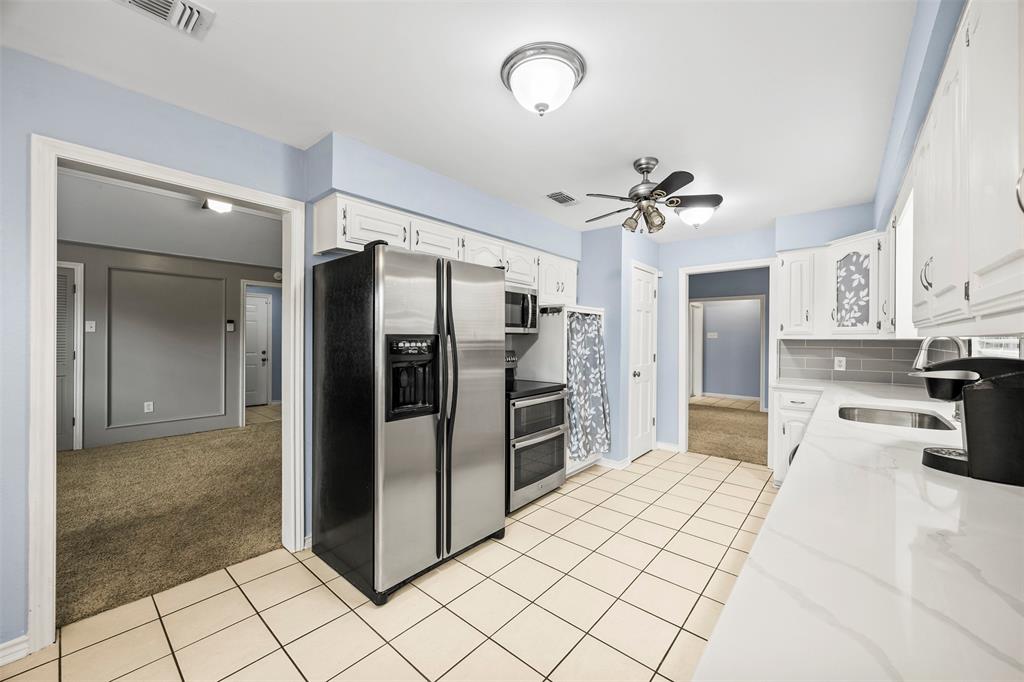 909 Valley View Avenue Red Oak, TX 75154 - Photo 14 of 37 a kitchen with stainless steel appliances a refrigerator and a sink