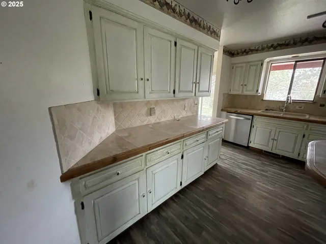 a kitchen with stainless steel appliances granite countertop a sink a stove and a wooden floors