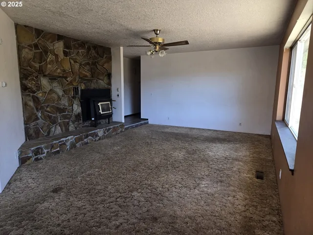 an empty room with windows and fireplace