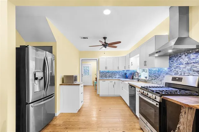 a kitchen with stainless steel appliances kitchen island granite countertop a sink and white cabinets