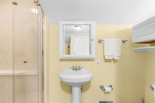 a bathroom with a sink shower and a mirror