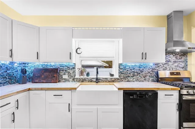 a kitchen with stainless steel appliances granite countertop a refrigerator a stove and a sink