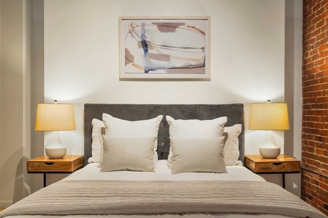 a spacious bedroom with a bed and a window