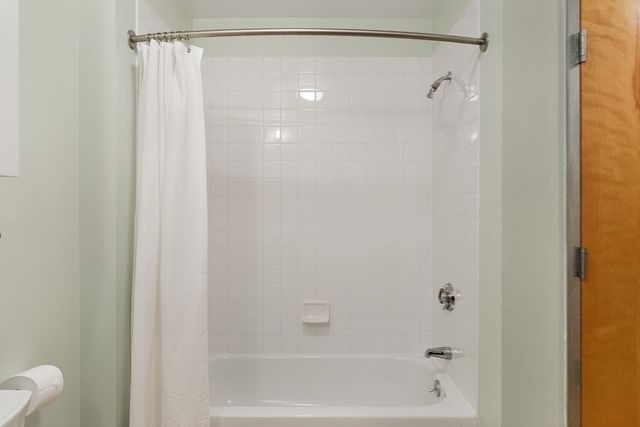 a bathroom with a granite countertop shower and a mirror