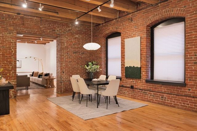 a kitchen with stainless steel appliances granite countertop a stove top oven a sink dishwasher and a refrigerator with wooden floor