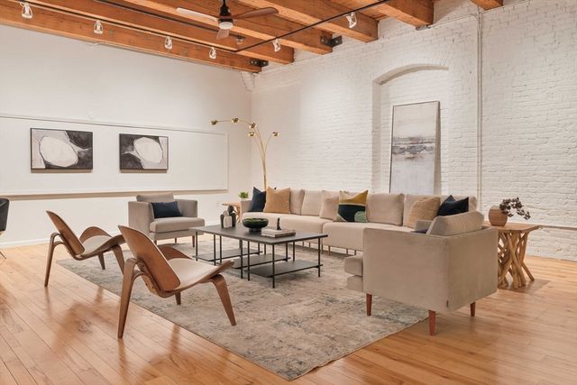 a living room with furniture and a wooden floor