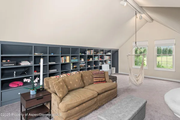 a living room with furniture a rug and white walls