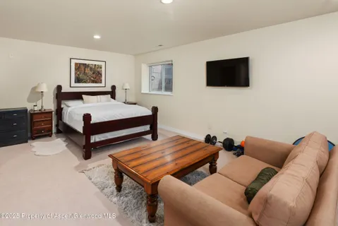a bedroom with furniture and a flat screen tv