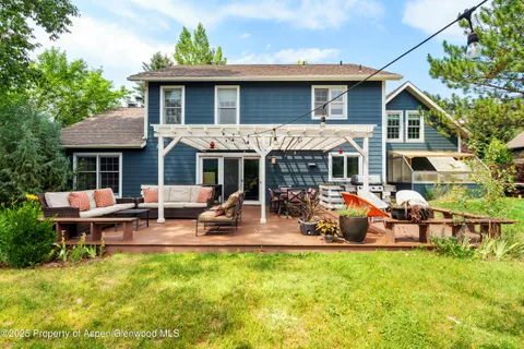 a view of a house with a patio and a yard