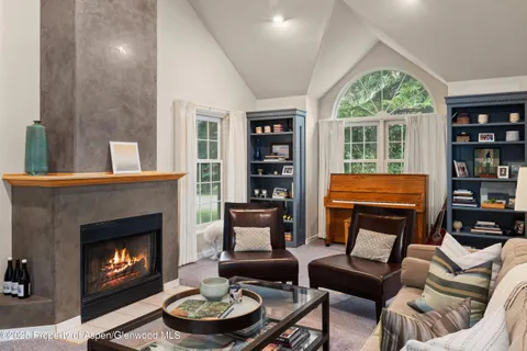 a living room with furniture a fireplace and a large window