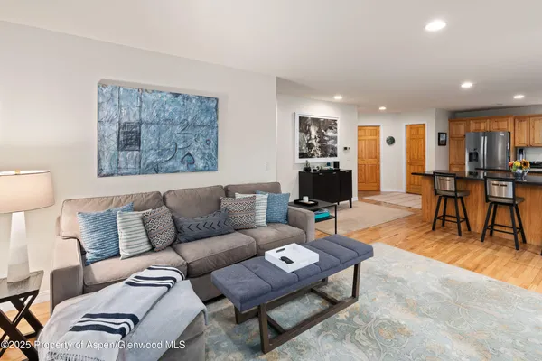 a living room with furniture and a dining table with kitchen view