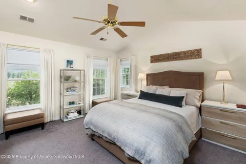 a spacious bedroom with a bed a couch and a window