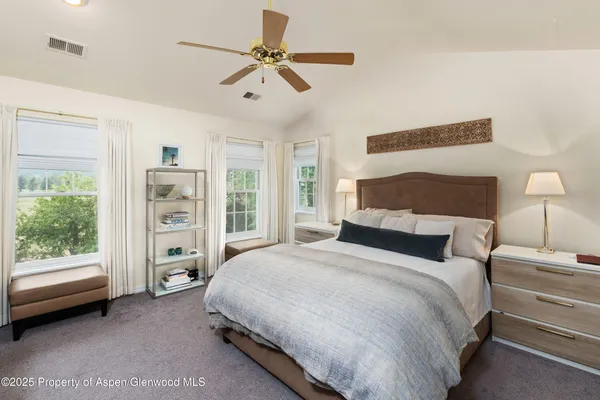 a spacious bedroom with a bed a couch and a window