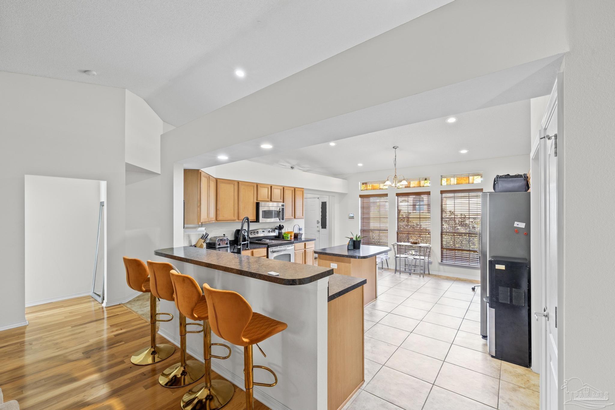 2165 Liberty Loop Road Cantonment, FL 32533 - Photo 19 of 51 a kitchen with stainless steel appliances a dining table chairs and a refrigerator