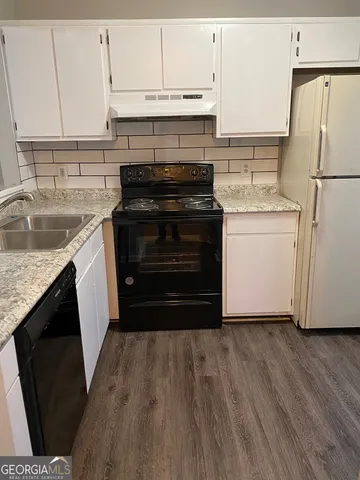 a kitchen with a refrigerator stove and white cabinets