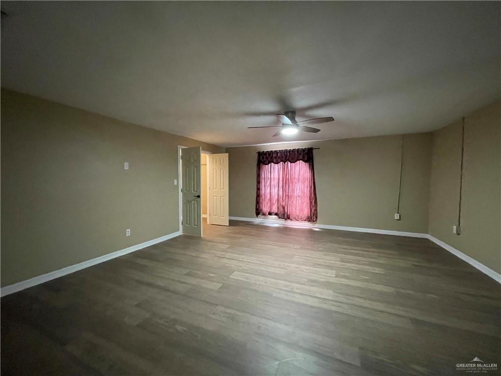 8006 Senecio Street Mission, TX 78574 - Photo 18 of 31 an empty room with wooden floor and windows