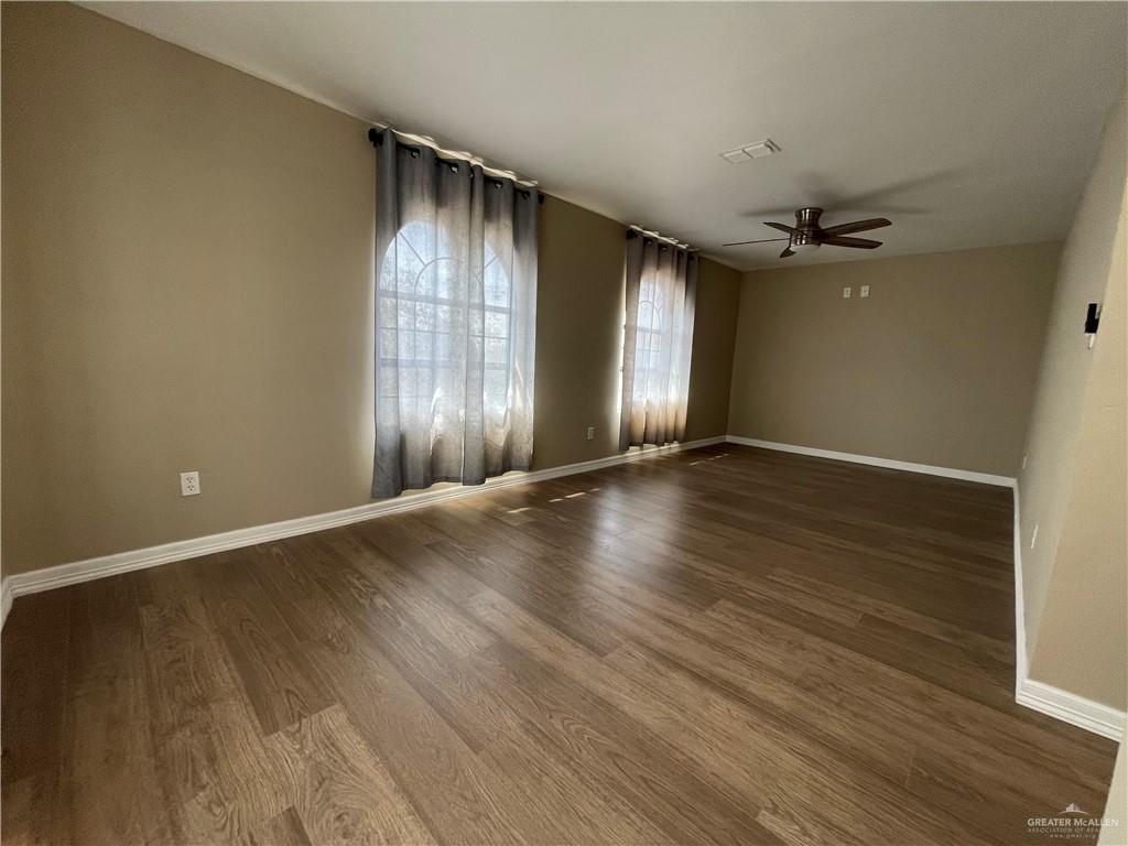 8006 Senecio Street Mission, TX 78574 - Photo 22 of 31 an empty room with wooden floor and windows