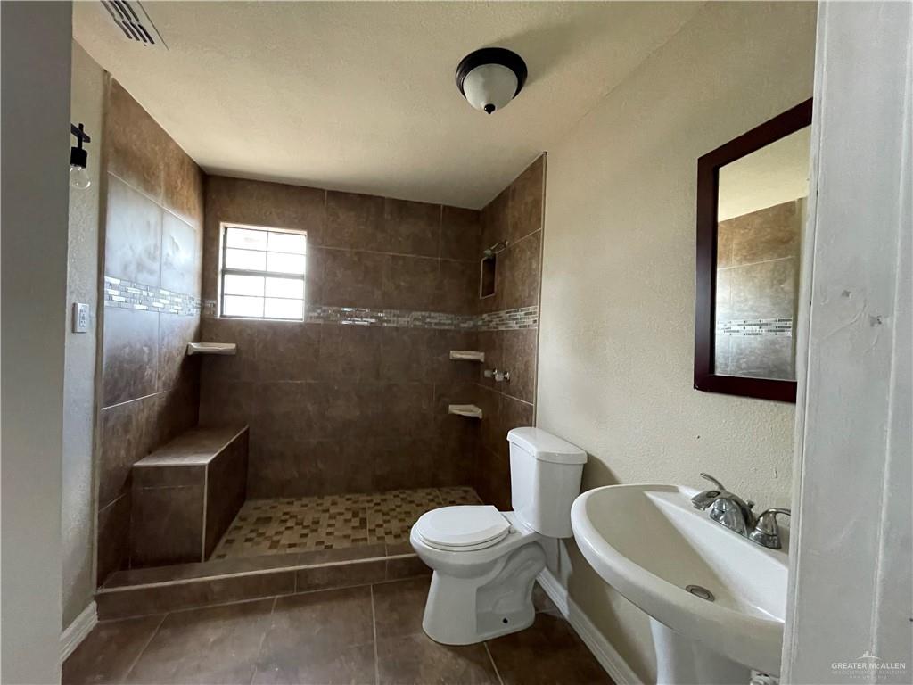 8006 Senecio Street Mission, TX 78574 - Photo 23 of 31 a bathroom with a sink toilet and shower