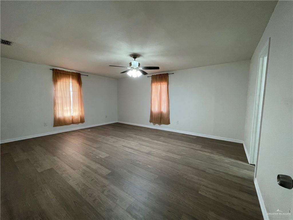 8006 Senecio Street Mission, TX 78574 - Photo 7 of 31 an empty room with wooden floor and windows