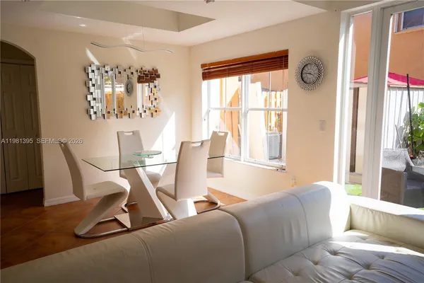 a living room with furniture a flat screen tv and a window