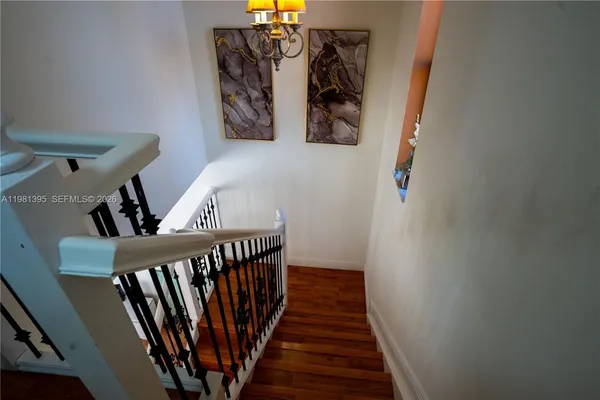 a view of a hallway with wooden floor and stairs