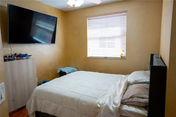 a bedroom with a bed and a flat tv screen on the dresser