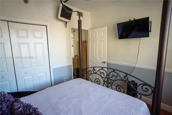a bedroom with a bed and a flat tv screen