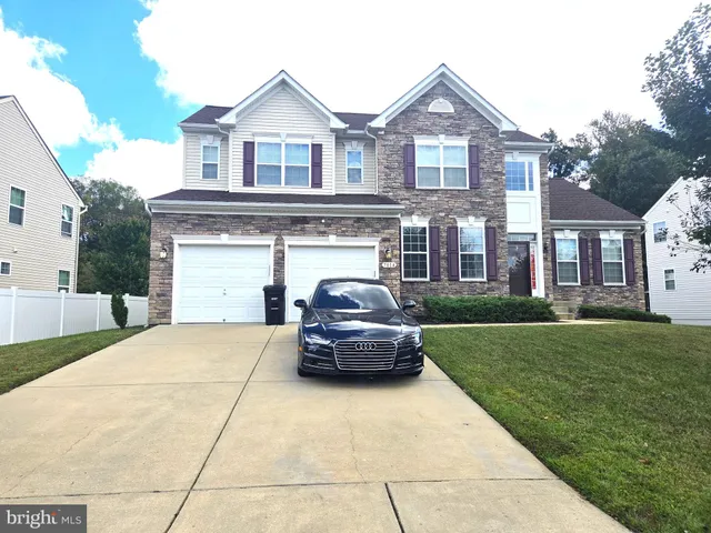 a car parked in front of a brick house with a large windows