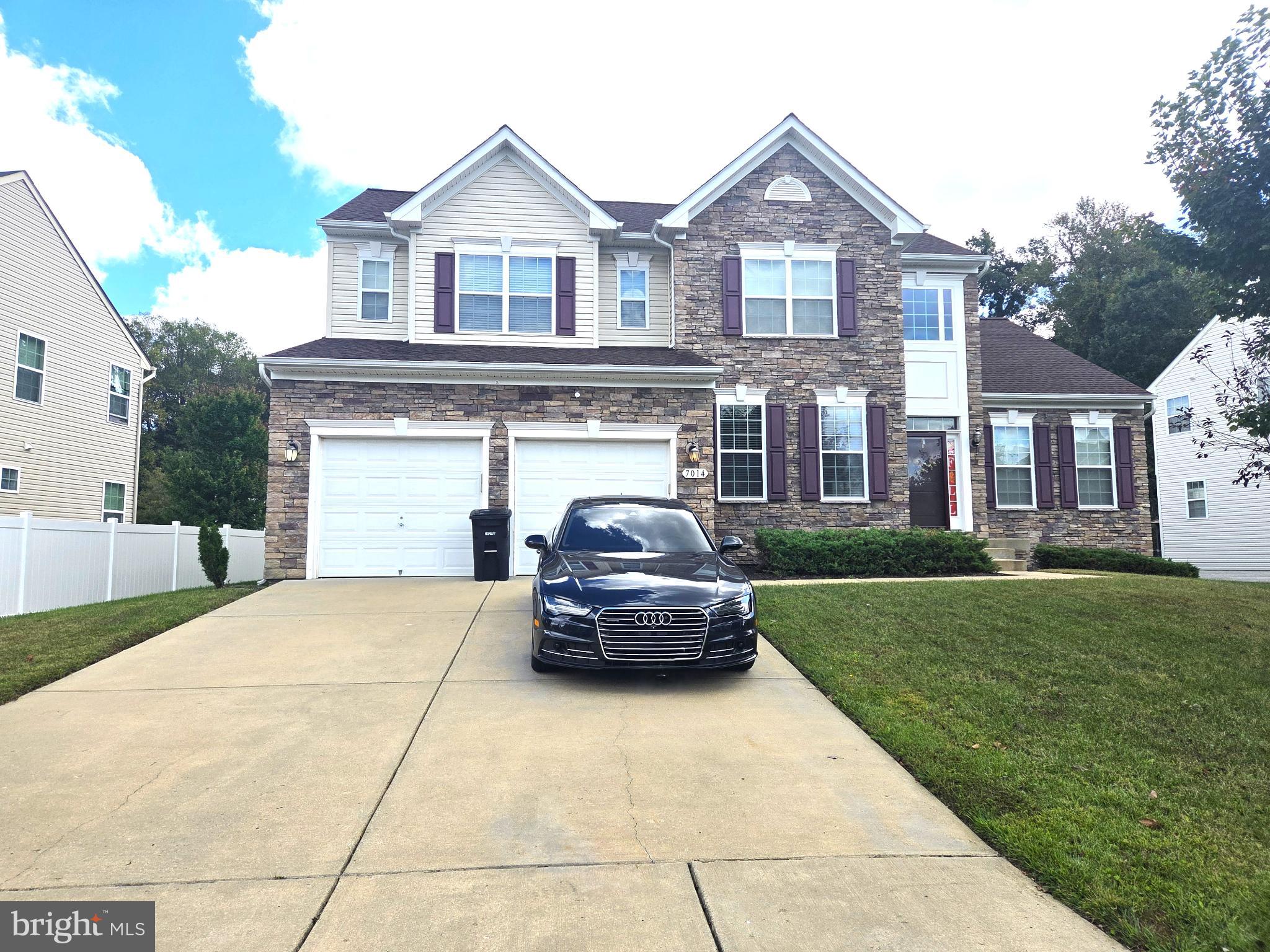 7014 Sand Cherry Way Clinton, MD 20735 - Photo 2 of 6 a car parked in front of a brick house with a large windows