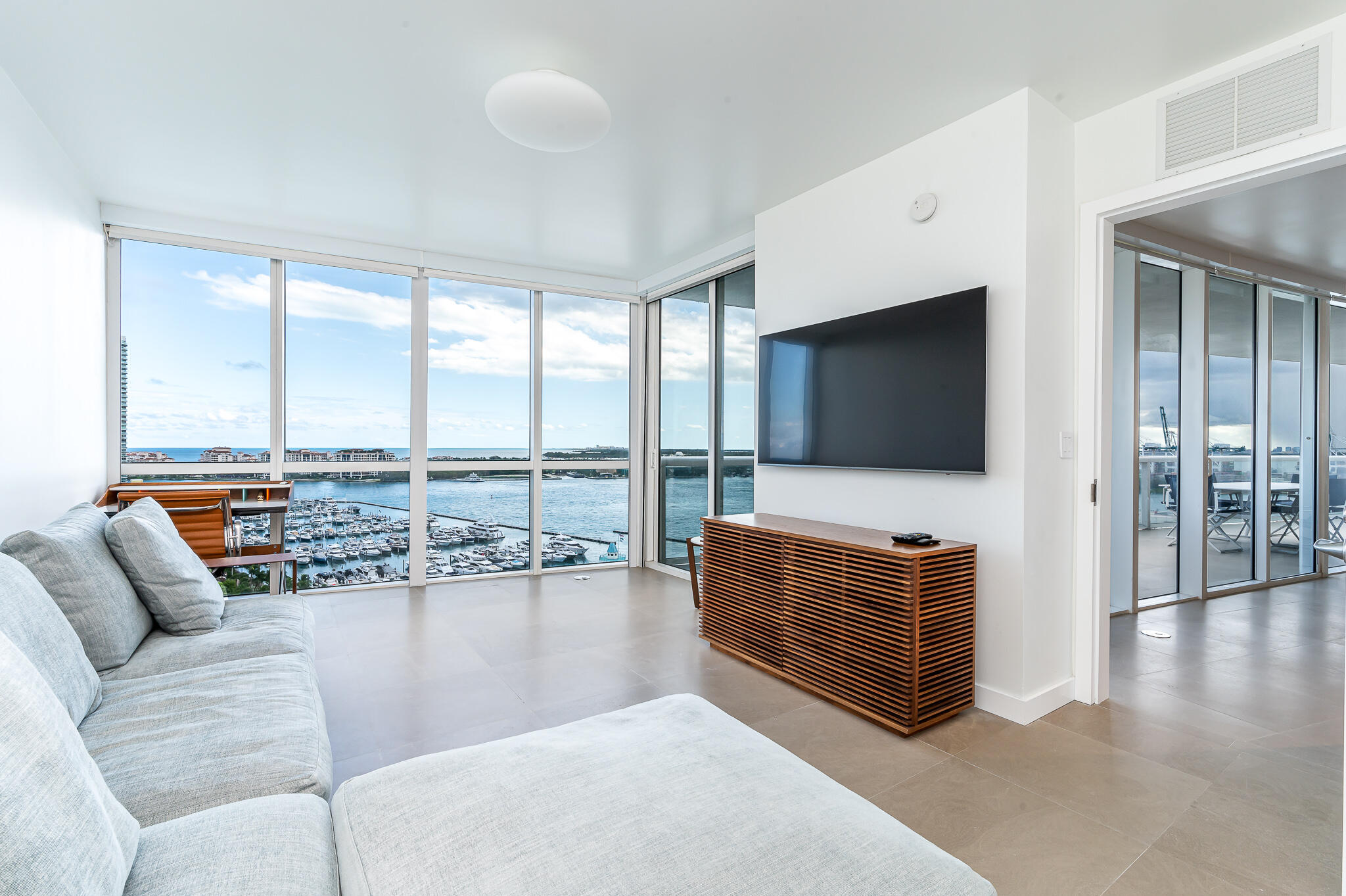 400 Alton Road, Unit 1808 Miami Beach, FL 33139 - Photo 10 of 17 a living room with furniture and a flat screen tv