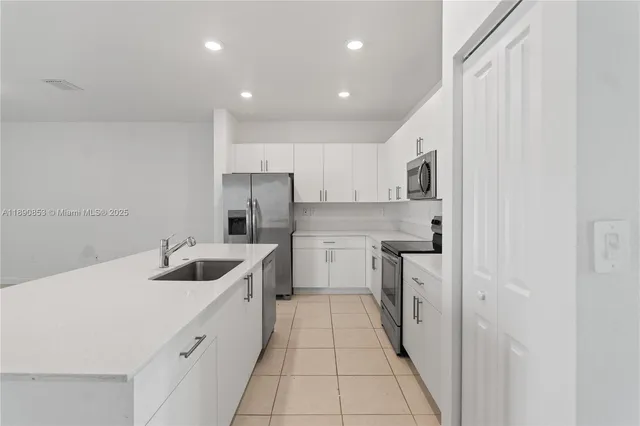 a kitchen with white cabinets and stainless steel appliances