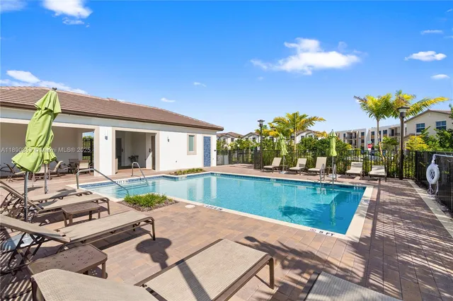 a view of a house with pool and chairs