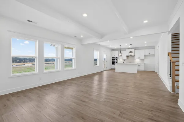 a view of empty room with wooden floor and windows