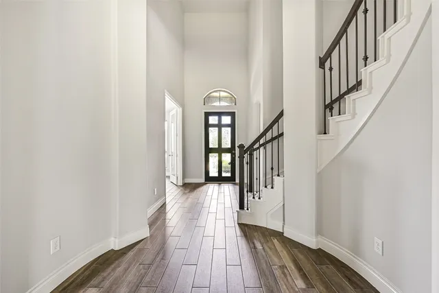 a view of a hallway with wooden floor and staircase