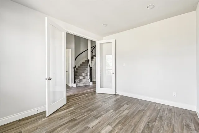 a view of a hallway with wooden floor and entryway