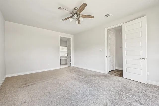 an empty room with closet and fan