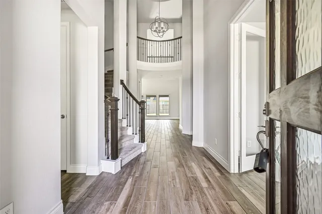 a view of a hallway with wooden floor and staircase