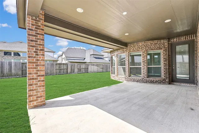 a view of a brick house with a big yard and large trees