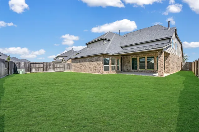 a view of a house with a big yard and large tree