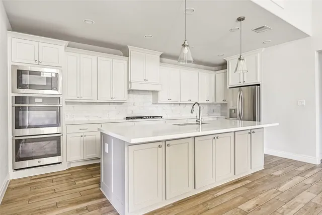 a kitchen with kitchen island granite countertop a sink stove and refrigerator