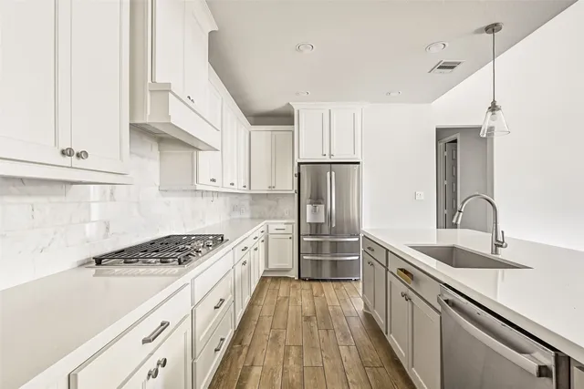 a kitchen with granite countertop a sink stove and refrigerator