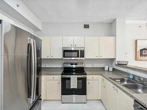 a kitchen with granite countertop a refrigerator sink and stove