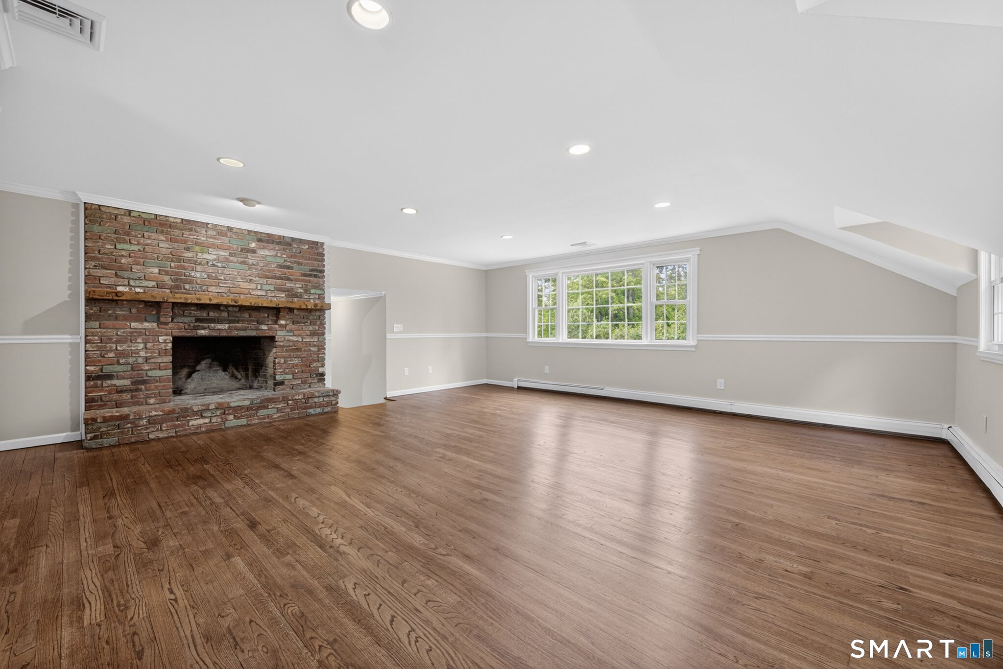 70 Barrack Hill Road Ridgefield, CT 06877 - Photo 3 of 32 an empty room with wooden floor fireplace and windows