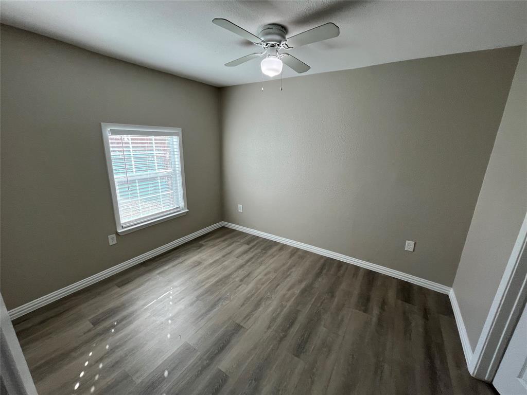 8335 Tenino Street Dallas, TX 75217 - Photo 11 of 22 Spare room featuring baseboards and dark wood finished floors