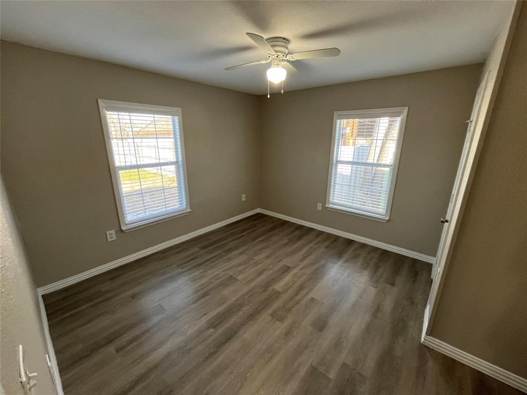 8335 Tenino Street Dallas, TX 75217 - Photo 15 of 22 Unfurnished room with dark wood-style flooring and ceiling fan