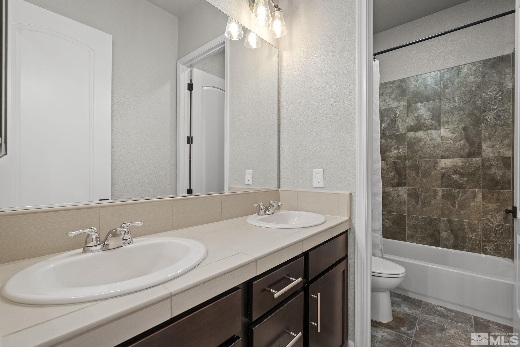 1755 Laurel Ridge Court Reno, NV 89523 - Photo 28 of 38 a bathroom with a granite countertop sink toilet a large mirror a shower and a bathtub