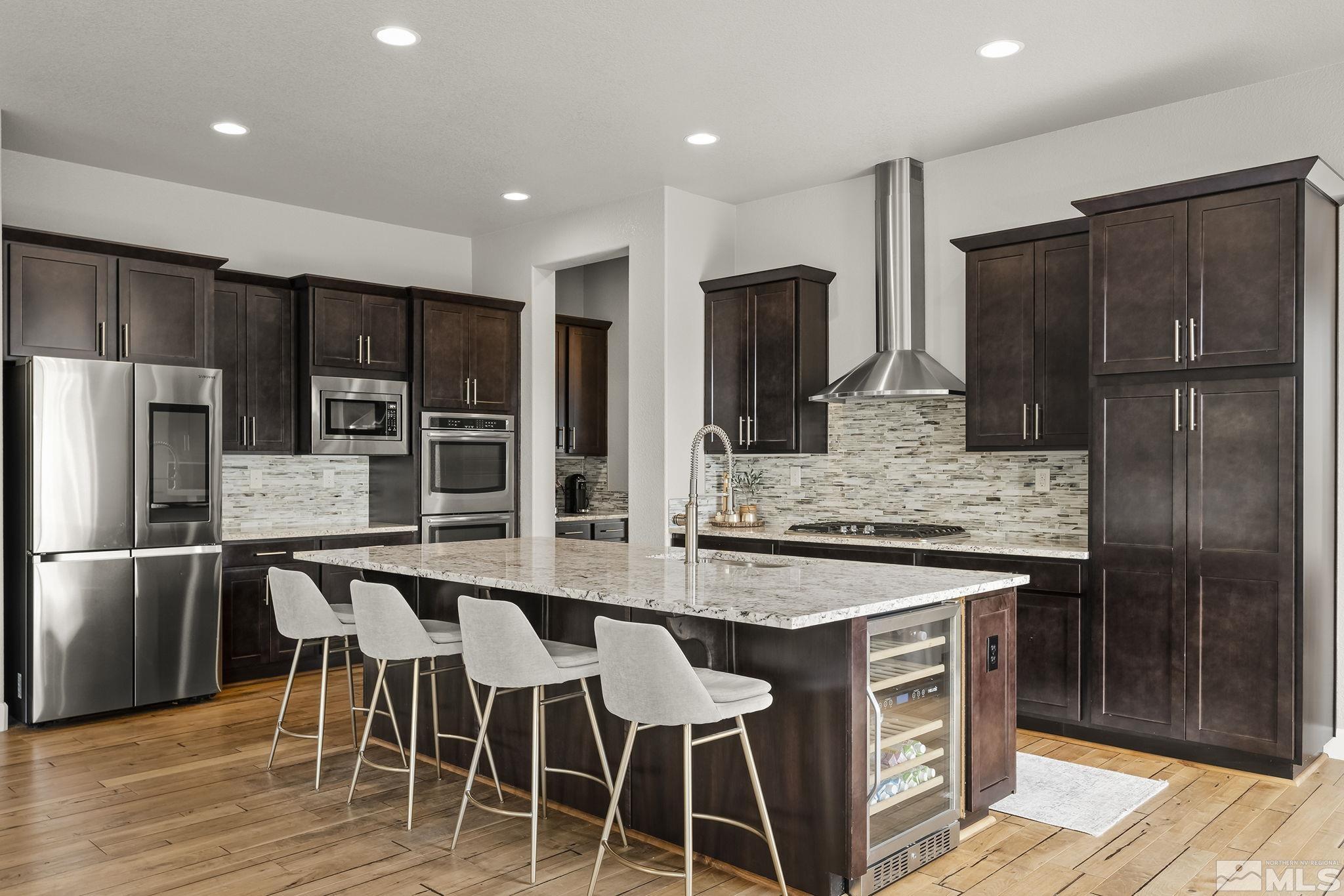1755 Laurel Ridge Court Reno, NV 89523 - Photo 10 of 38 a kitchen with stainless steel appliances granite countertop a table chairs refrigerator and a sink
