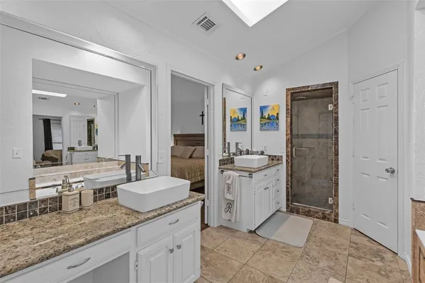 a bathroom with a granite countertop sink mirror and shower