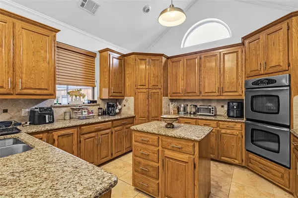 a kitchen with stainless steel appliances granite countertop a stove sink and cabinets