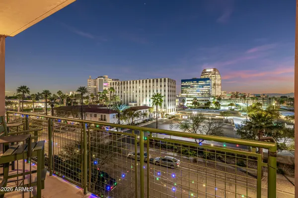 a kitchen with stainless steel appliances kitchen island granite countertop a refrigerator a stove a sink and a dining table with wooden floor